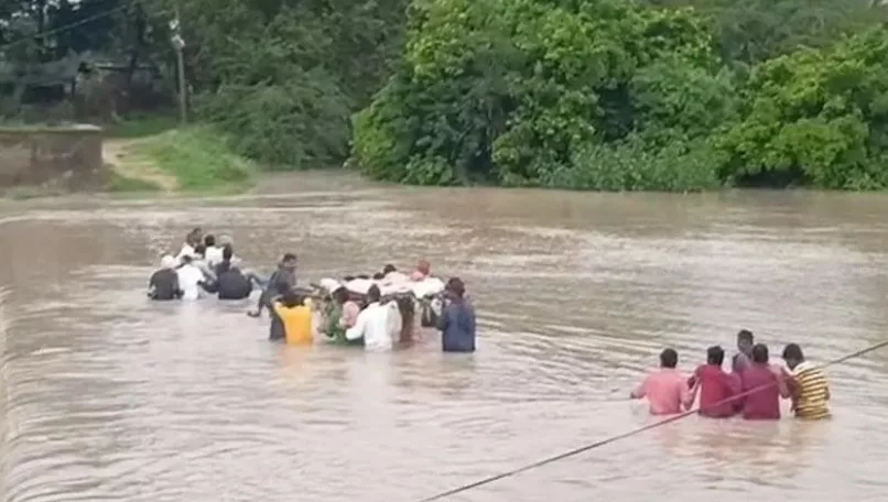 villagers and relatives swim in the overflowing stream for the last ritesof the deceased in siddipet dist